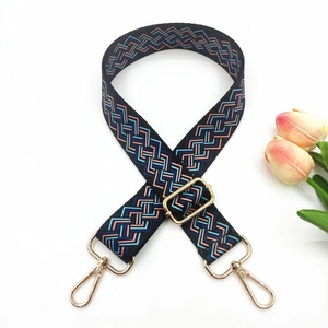 Close-up of geometric woven shoulder strap in blue and pink with gold metal hardware