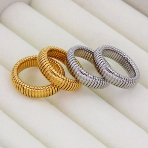 Detailed macro view of gold and silver coiled flexible snake rings on white velvet display