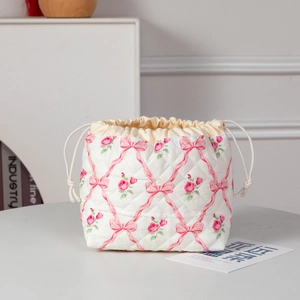 Detailed view of quilted makeup bag with pink floral patterns and drawstring closure