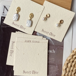 Detail showing elegant pearl earrings on premium Sweet Olive jewelry display cards