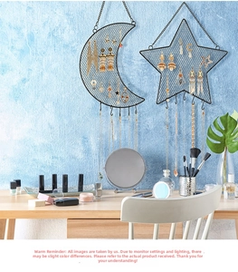 Macro detail of wall-mounted star and moon metal mesh earring organizer with bottom hooks