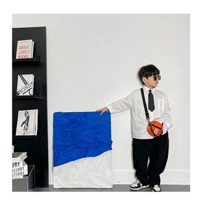 Détail du petit sac rond orange pour enfant en nylon avec chaîne noire et sangle réglable