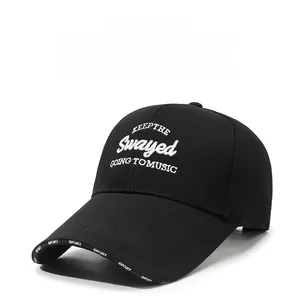 Detail of white letter embroidery and SPORT print on a black cotton baseball cap