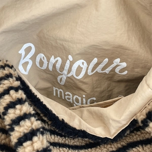 Detail of plush striped fabric and Bonjour magic print inside the fluffy tote bag