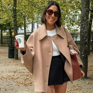 Outdoor shot of a beige oversized wool jacket with lapels and single-breasted design