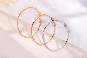 Close-up of Hope engraved Tree of Life bangles in gold, rose gold and silver finishes