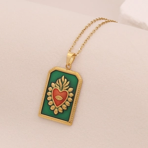 Détail du pendentif tarot cœur en émail vert avec cœur rouge et collier doré chic