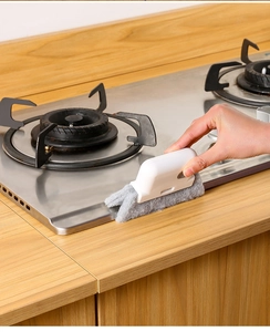 Detail of 2-in-1 window groove cleaning brush removing dirt from a gas stove edge