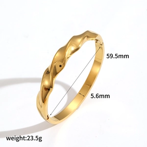 Detail of gold wavy stainless steel bangle with 59.5mm diameter and 5.6mm width measurements