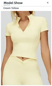 Dettaglio del top sportivo giallo crema con collo alto e cerniera a vestibilità slim