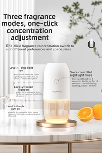 Detailed view of white smart fragrance diffuser spraying mist with ambient light and orange decor