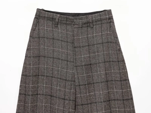Gros plan détaillé d'un pantalon à carreaux gris avec texture tissée et passants de ceinture