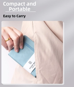 Close-up of a compact grey-blue leather pocket book with a paper belly band