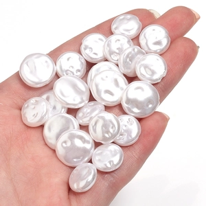 Detailed view of irregular white ABS imitation pearl beads held in hand for DIY jewelry
