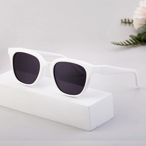 Stylish cat-eye polarized sunglasses with white thick frames and black lenses on white base