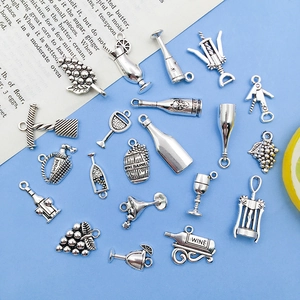 Detailed close-up of antique silver wine charms including corkscrew and goblet pendants