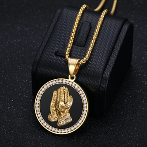 Gold plated hiphop necklace featuring a zircon encrusted praying hands medallion pendant