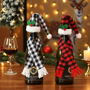 Close-up of mini Christmas hats and scarves set on wine bottles for festive table decor