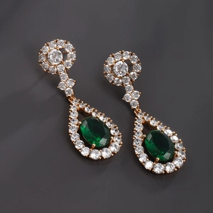 Detailed macro of vintage emerald green teardrop earrings with halo diamond settings
