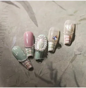 Macro shot of 3D embossed tulip and butterfly press-on nails with pearl details