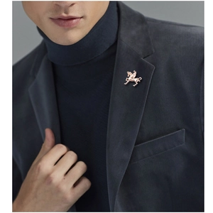 Detail of golden Pegasus brooch pinned on a dark blue suit lapel for classic style