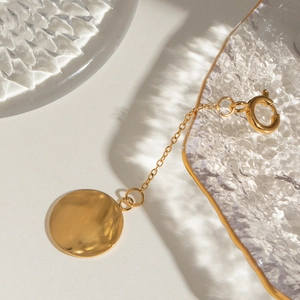 18k gold plated stainless steel bikini pendant link on a luxury glass tray setting