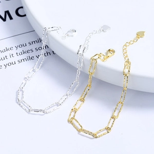 Detail of double-layer silver star bracelets with paperclip chain and lobster clasp