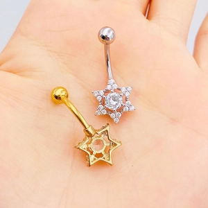 Stainless steel belly rings with star-shaped cubic zirconia held in a palm for scale