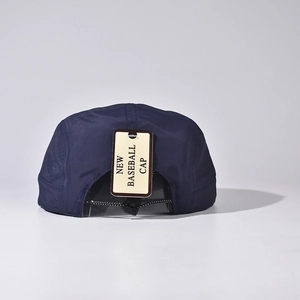 Détail d'une casquette bleu marine avec trous d'aération et cordon de réglage arrière