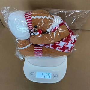 Detailed view of gingerbread man wine bottle cover on a scale weighing 113.6g