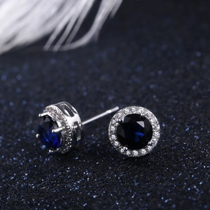 Macro shot of classic round blue zircon stud earrings with white micro-pave setting