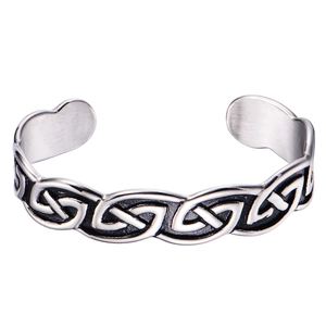 Detailed view of silver Celtic knot patterns on vintage stainless steel Viking cuff