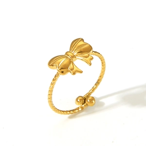 Detail of golden butterfly open ring featuring twisted band and polished bead accents