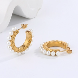 Elegant C-shaped golden earrings with white pearls and twisted metal texture