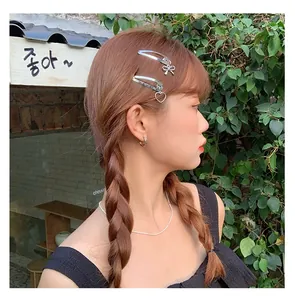 Detail of silver bow hair clip and necklace set styled on a model for a cool girl look