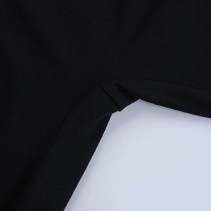 Detail of the high-quality stitching and tight knit texture on a black slim jumpsuit