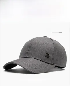 Detail of light gray textured baseball cap with metallic R logo on white background