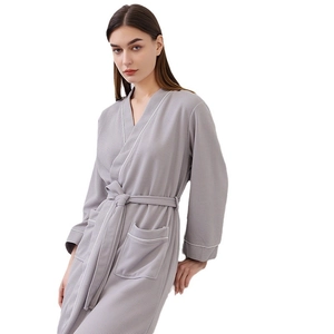 Gray waffle weave bathrobe for adults featuring contrasting white piping and front pockets