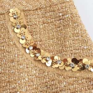 Elegant tweed jacket set with gold sequins and beads, showing premium fabric details