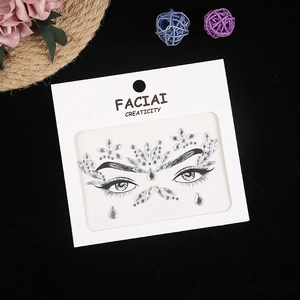 Close-up of iridescent crystal face jewels on facial creativity card packaging with dry flowers