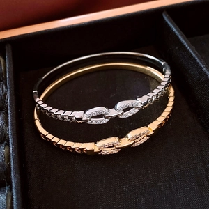 Detail of 18K gold and silver plated bangles with zircon inlay on black velvet
