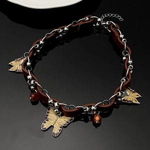Detail of Y2K leather choker with metal chains, butterfly charms and amber beads