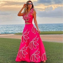 Detail of rose pink halter dress featuring oversized white 3D floral petal decorations