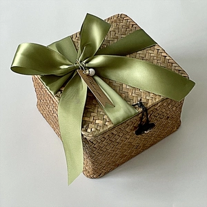 Detail of square hand-woven gift box with green ribbon and Thank You pearl tag