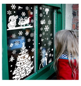 Girl looking at white Christmas window decals featuring Santa, reindeer and snowflakes