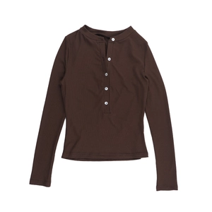Close-up of brown rib-knit texture and white buttons on a long sleeve Henley shirt