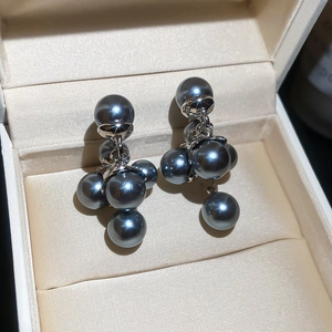Macro detail of French vintage grey pearl cluster earrings in a beige jewelry box