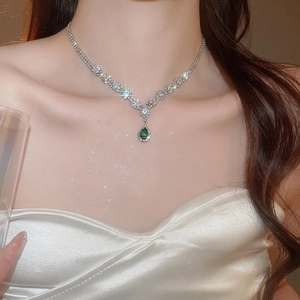 Close-up of model wearing silver necklace with green pear-cut zircon teardrop pendant