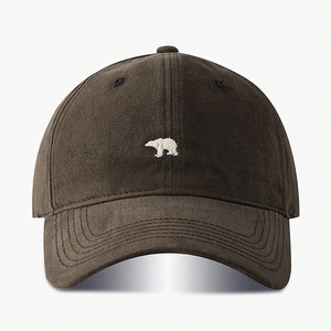 Close-up of a dark brown cotton baseball cap featuring white polar bear embroidery