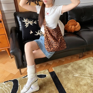 Lifestyle shot of a stylish leopard print canvas crossbody bag with large capacity